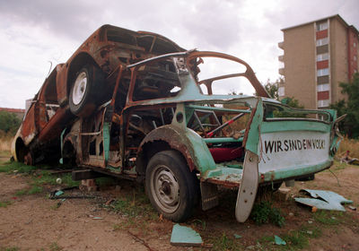 Abandoned vehicle on field against sky