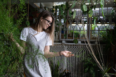 Beautiful woman standing by plants