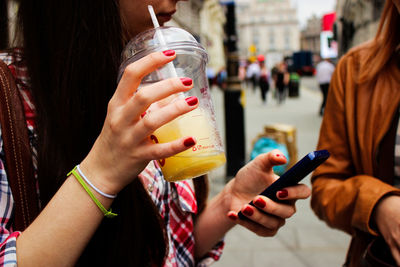 Midsection of woman using mobile phone