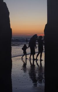 Silhouette people at beach during sunset