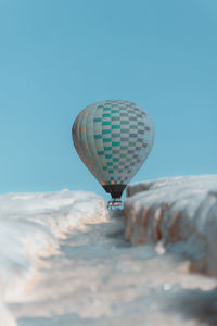 Low angle view of hot air balloon against clear blue sky