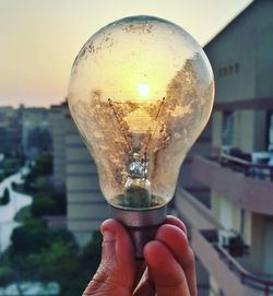 Close-up of hand holding light bulb