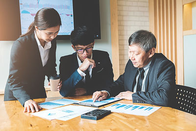 Colleagues working over graph at desk in office