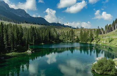 Scenic view of lake by trees against sky