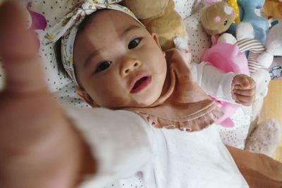 Portrait of cute baby lying on bed