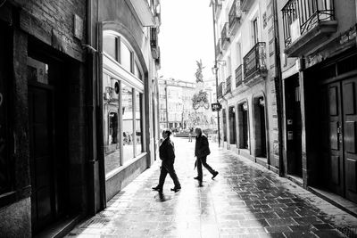 Men walking on street amidst building