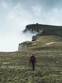 Rear view of woman hiking against sky