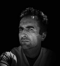 Portrait of young man against black background