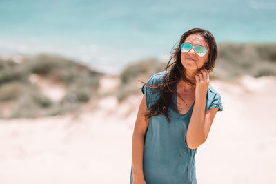 Midsection of woman wearing sunglasses standing outdoors