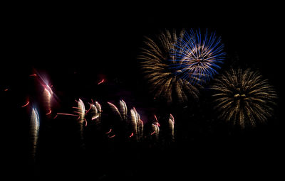 Low angle view of firework display at night