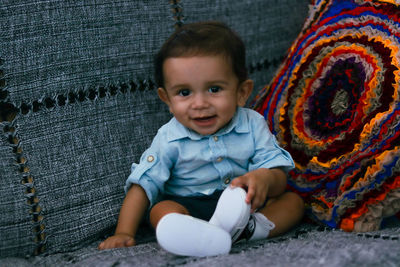 Portrait of cute boy sitting on sofa