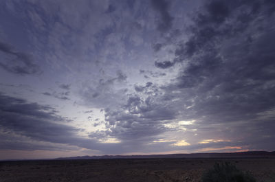 Scenic view of desert against sky during sunset