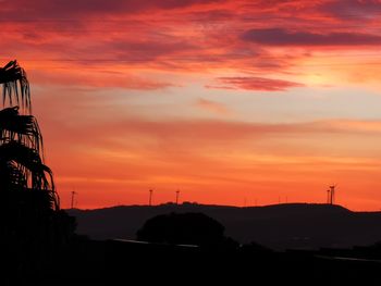 Silhouette landscape against romantic sky at sunset