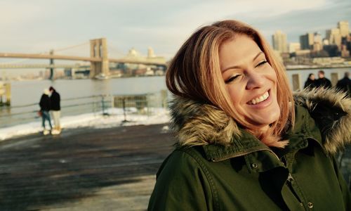 Portrait of smiling young woman with river in background