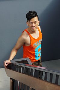 Portrait of man standing by railing on staircase