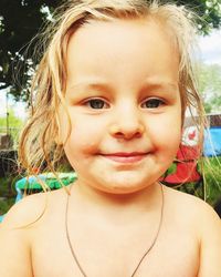 Close-up portrait of shirtless smiling girl outdoors