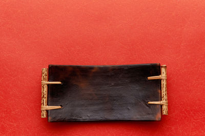 Directly above shot of empty wooden tray on red background