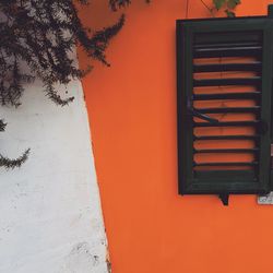 Close-up of window on orange wall