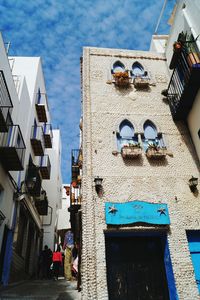 Low angle view of buildings in town against sky