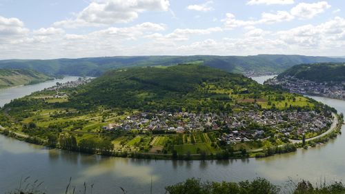 Scenic view of river by townscape against sky