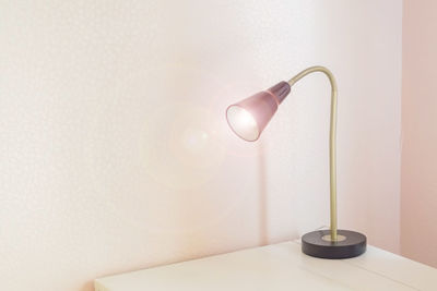 Desk lamp with light on of white table, freelance working place concept