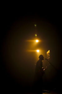 Silhouette people standing in dark room