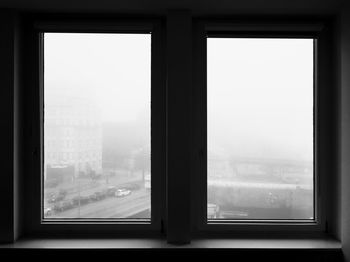 City during foggy weather seen from window