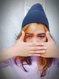 Portrait of a beautiful young woman covering face