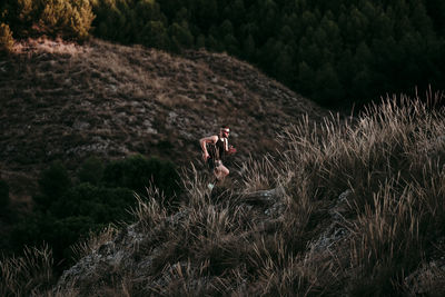 Young sportsman with determination running on mountain during sunset