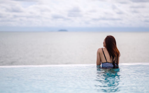 Rear view of woman swimming in sea