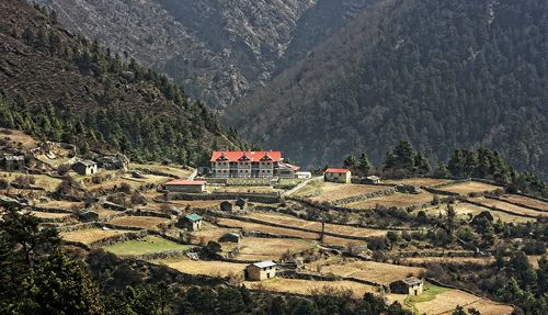 High angle view of buildings, agricultural fields and mountains