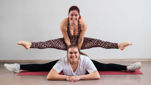 Athletes practicing yoga against wall