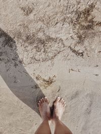 Low section of person standing on sand