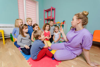 Rear view of people sitting on wooden floor