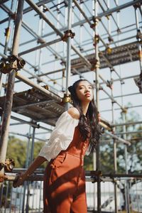 Young woman against scaffolding