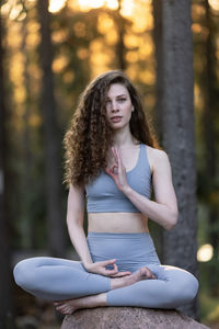 Portrait of young woman sitting in forest