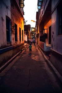 Man walking on road along buildings