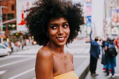 Thoughtful young woman with afro hairstyle at city street