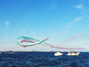 Airplane flying over sea against blue sky