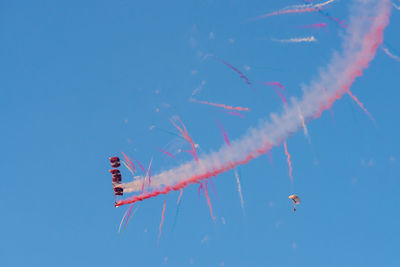 Low angle view of airplane flying against blue sky