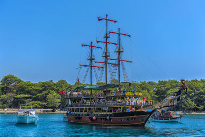 Sailboat sailing on sea against clear blue sky