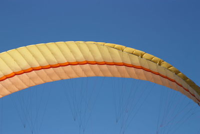 Low angle close-up of parachute against clear blue sky