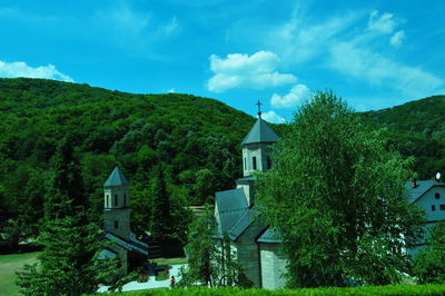 Built structure by trees against sky
