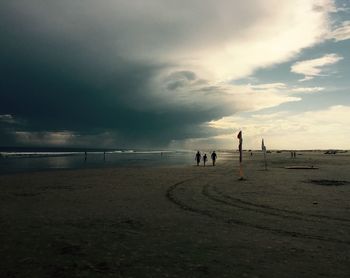 Scenic view of beach against cloudy sky