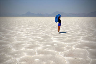 Rear view of woman walking on beach