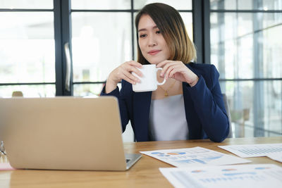 Young woman drinking coffee at table