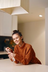 Young woman using mobile phone while sitting at home