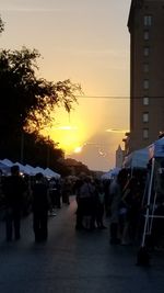 People walking on street at sunset