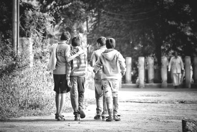 Rear view of friends walking on street