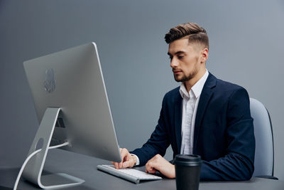 Businessman using desktop pc at desk in office